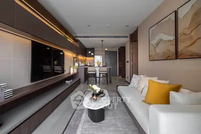 Modern living room with stylish decor and open kitchen layout, featuring elegant furniture and contemporary art.