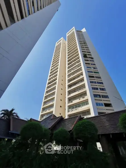 Stunning high-rise building with modern architecture against a clear blue sky, perfect for urban living.