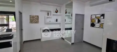 Modern living room with sleek design and stylish decor, featuring wall art and contemporary shelving.