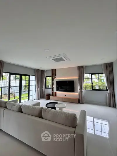 Spacious modern living room with large windows and elegant decor