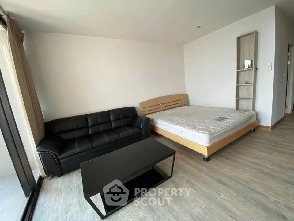 Spacious studio apartment with modern furnishings and large windows for natural light.