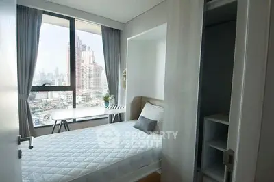 Modern bedroom with city view, featuring a cozy bed and stylish decor in a high-rise apartment.