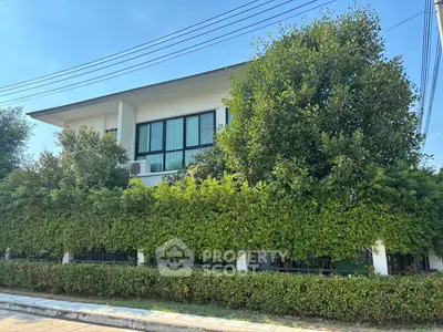 Modern two-story house with lush greenery and large windows
