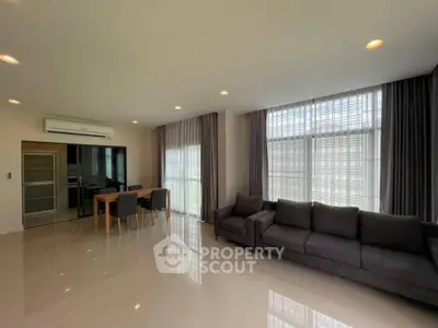 Spacious modern living room with large windows and elegant furnishings