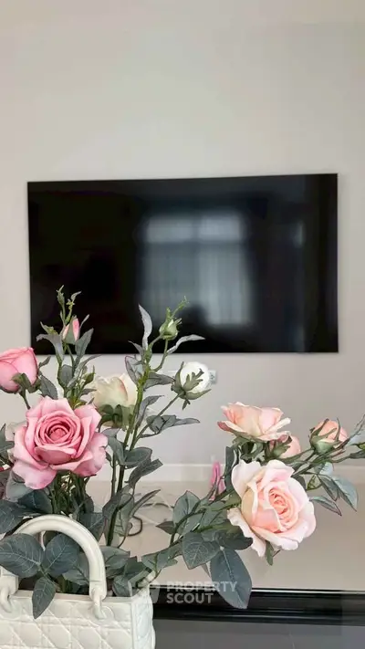 Modern living room with elegant floral decor and wall-mounted TV