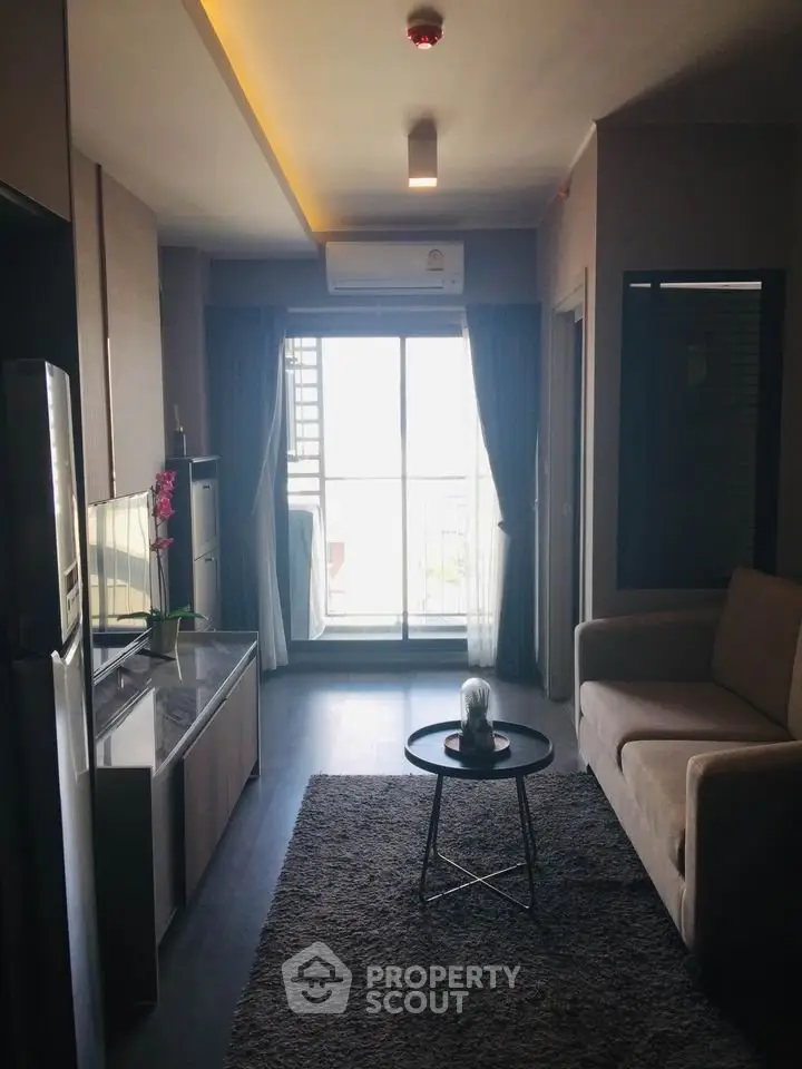 Modern living room with balcony access, featuring sleek furniture and natural light.