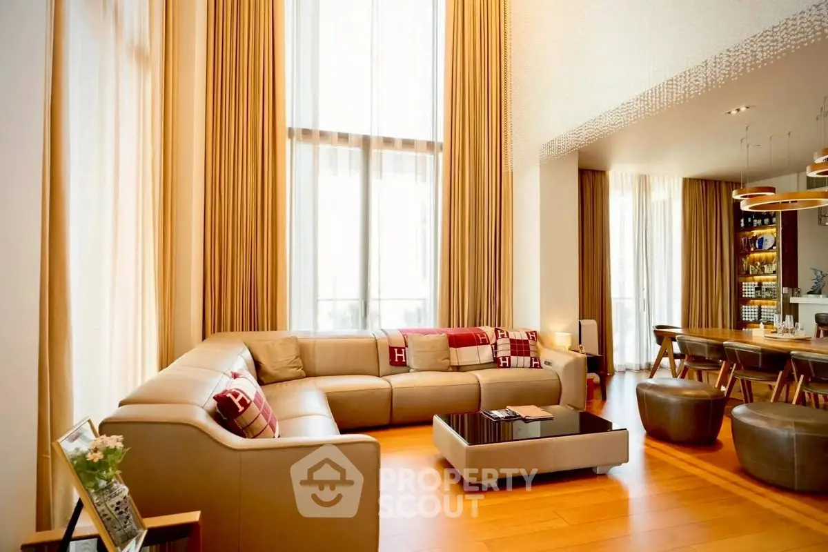 Luxurious living room with high ceilings and elegant decor, featuring a spacious seating area and modern dining space.