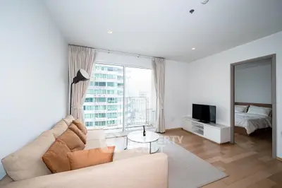 Modern living room with cozy sofa, TV, and city view balcony in a stylish apartment.