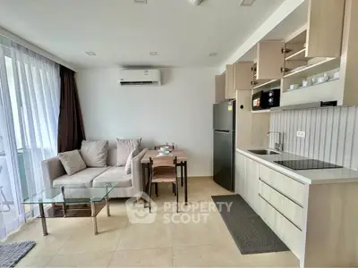 Modern open-plan living room with kitchen, featuring sleek furniture and natural light.