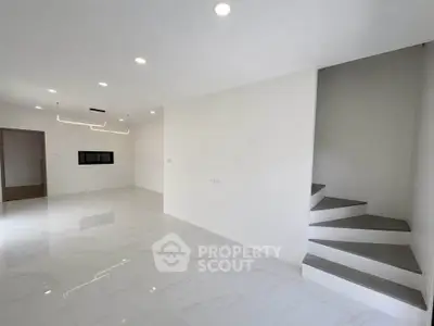 Spacious modern living room with sleek staircase and elegant lighting