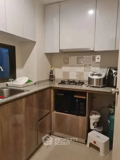 Modern kitchen with gas stove and sleek cabinetry in compact layout