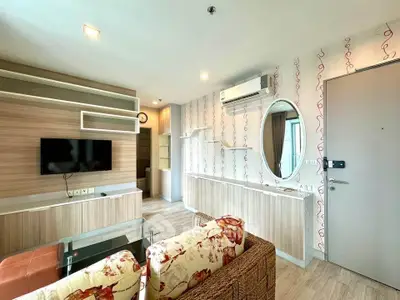 Charming living room with modern decor, featuring a wall-mounted TV and stylish shelving.