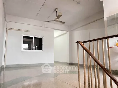 Spacious interior with ceiling fan and staircase, ideal for versatile living arrangements.