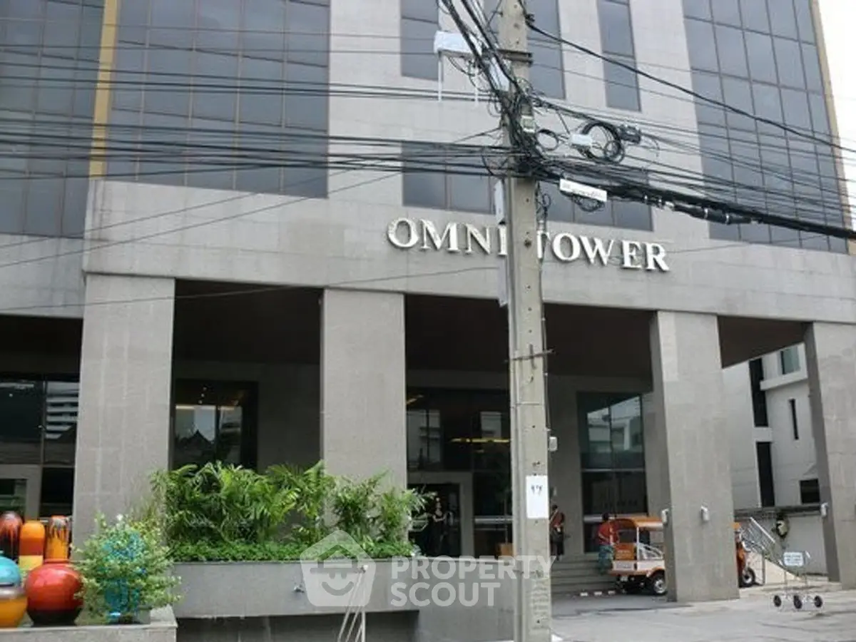 Modern commercial building entrance with lush greenery and urban setting