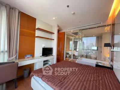 Modern bedroom with glass-walled bathroom and city view, featuring sleek design and warm lighting.