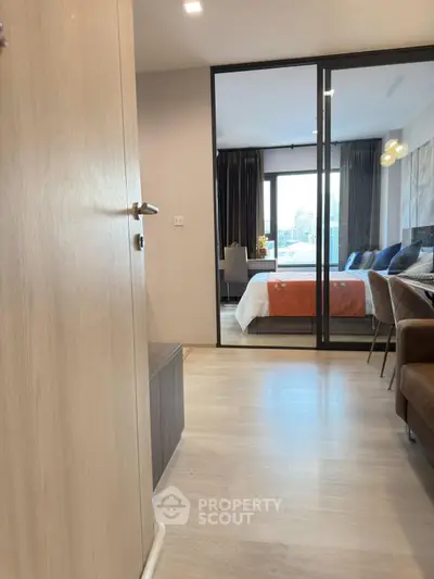 Modern apartment interior with sliding glass doors leading to a stylish bedroom.