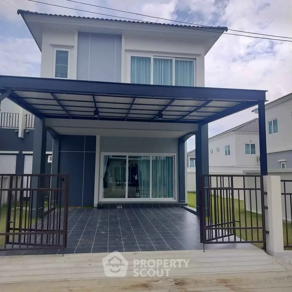 Modern two-story house with sleek design and spacious patio in a serene neighborhood.