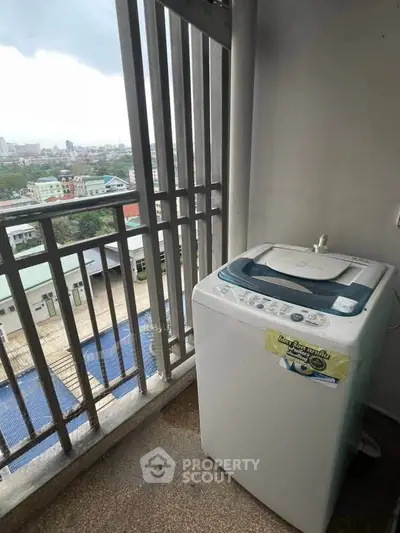 Balcony with washing machine and city view, perfect for urban living convenience.