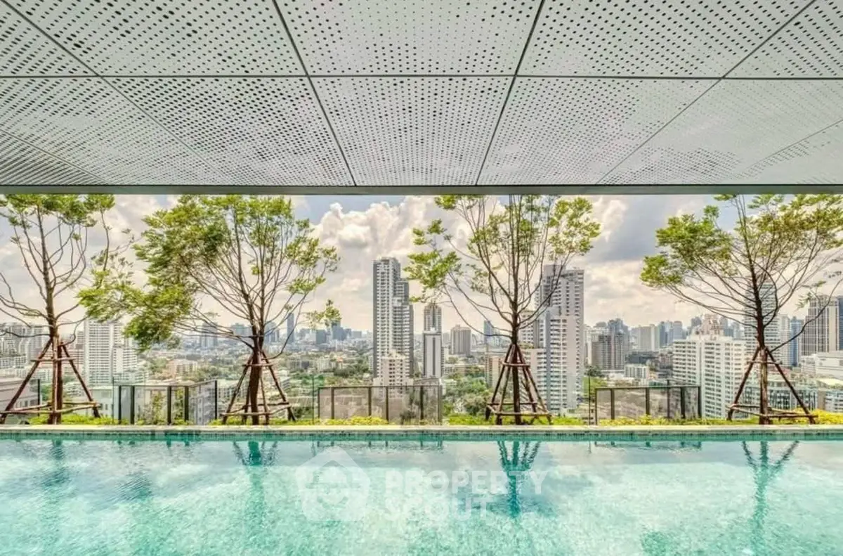 Luxurious rooftop pool with stunning city skyline view and lush greenery.