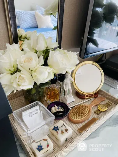 Elegant bedroom vanity setup with fresh white roses and decorative accessories.