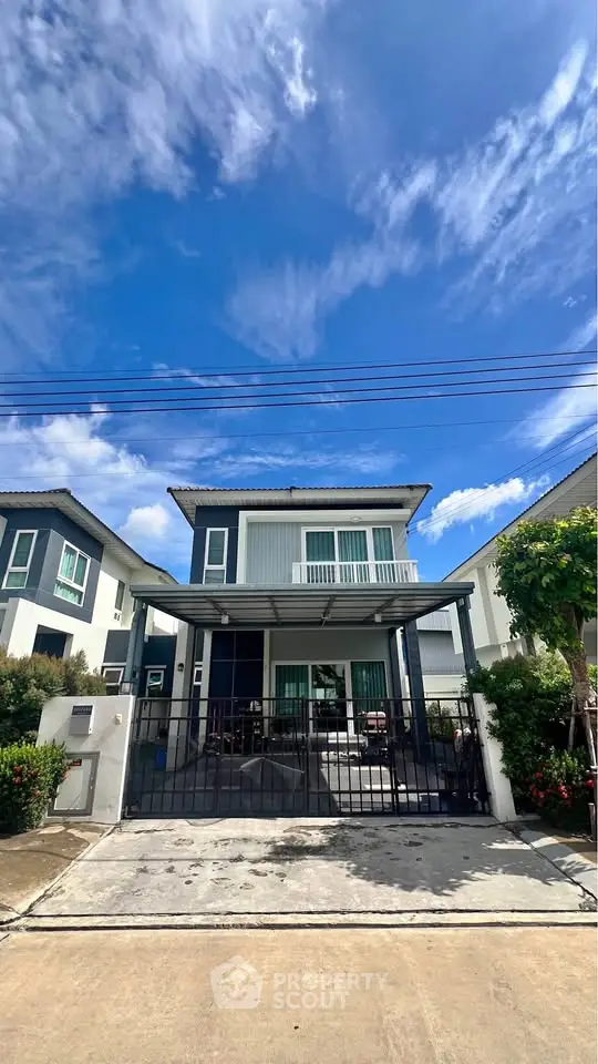 Charming two-story house with modern design and spacious driveway under a clear blue sky.