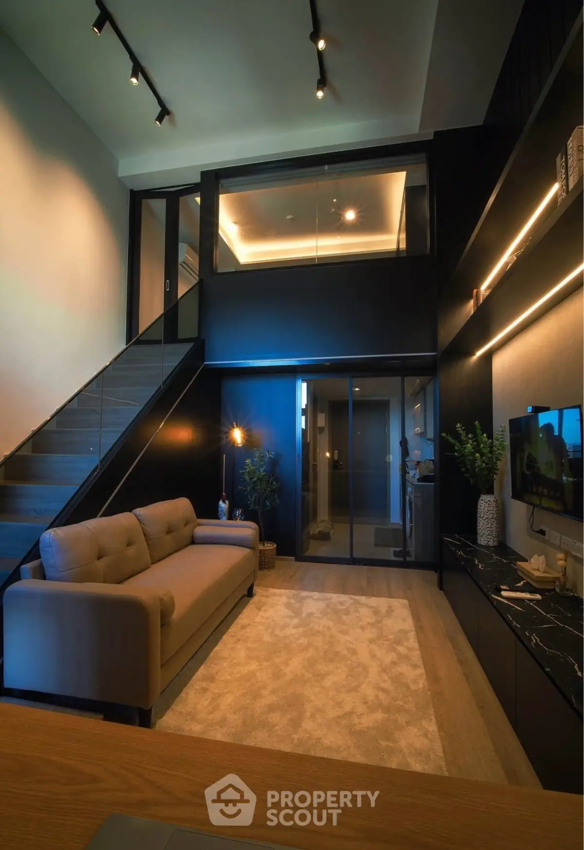 Luxurious modern living room with high ceiling and mezzanine, featuring elegant lighting and stylish decor.