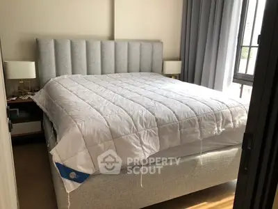 Cozy bedroom with plush bed and natural light from large window