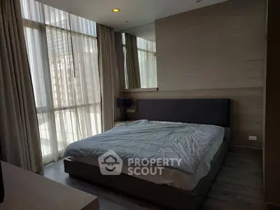 Modern bedroom with large windows and stylish decor in urban apartment
