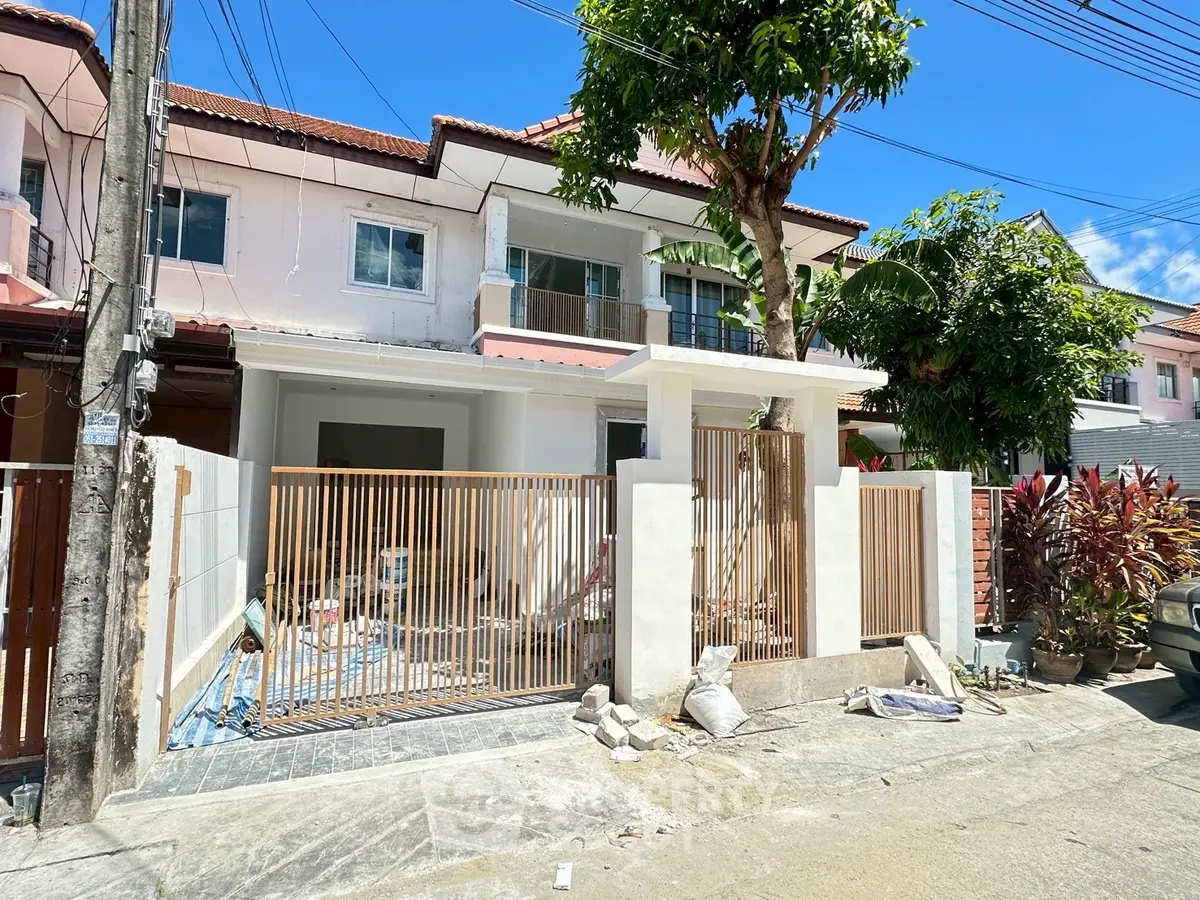Charming townhouse with modern facade and lush greenery in a serene neighborhood.