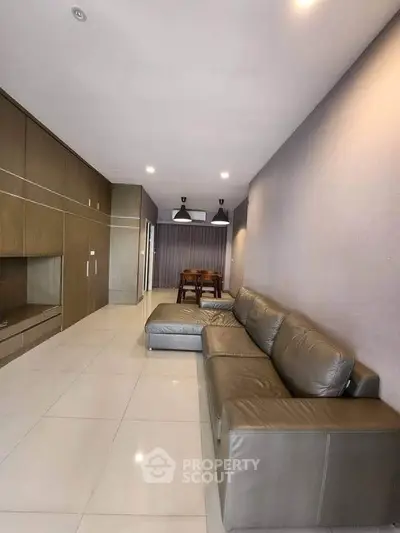 Spacious modern living room with sleek leather sofa and elegant dining area