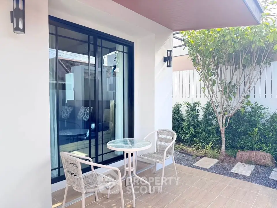 Charming patio with cozy seating and garden view, perfect for relaxation and outdoor enjoyment.
