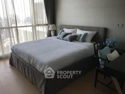 Spacious bedroom with modern decor and large window offering city view