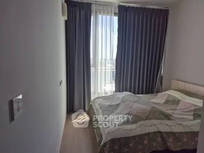 Cozy bedroom with large window and elegant curtains, featuring a comfortable bed and serene ambiance.