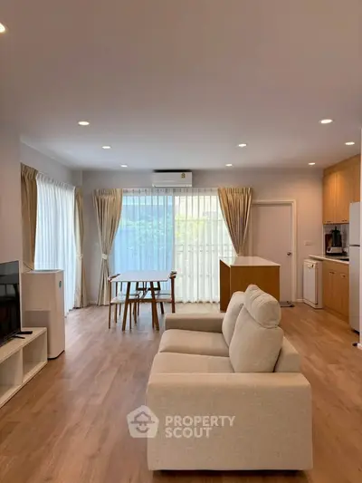 Spacious modern living room with open kitchen and natural light