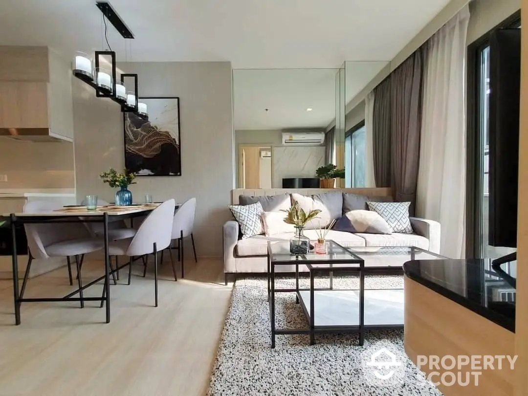 Elegant open-concept living space with modern furniture, natural light, and a seamless transition to a stylish dining area, perfect for entertaining.