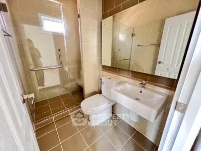 Modern bathroom with glass shower and sleek fixtures in a contemporary home.