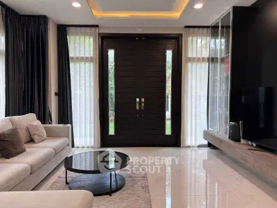 Luxurious living room with modern decor and large double doors leading to a garden view.
