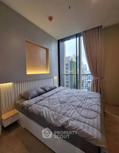 Modern bedroom with large window and city view, featuring stylish lighting and elegant decor.