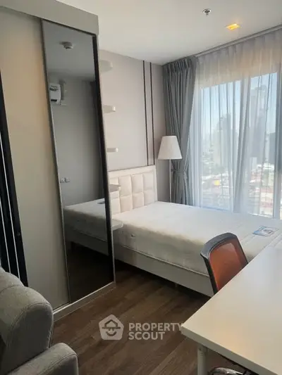 Modern bedroom with city view, featuring a cozy bed, stylish decor, and ample natural light.