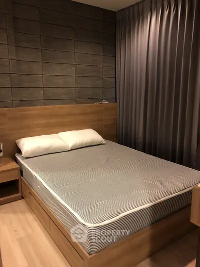 Modern bedroom with wooden furniture and stylish curtains in a cozy apartment.