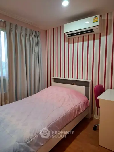 Cozy bedroom with striped wallpaper and air conditioning, perfect for comfort and style.