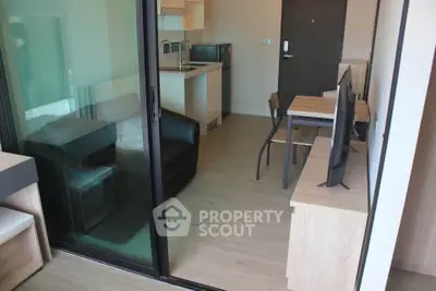 Modern apartment interior with open layout, featuring a cozy living area and compact kitchen.