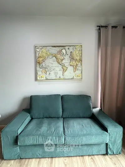 Stylish living room with a teal sofa and world map artwork, perfect for modern home decor.