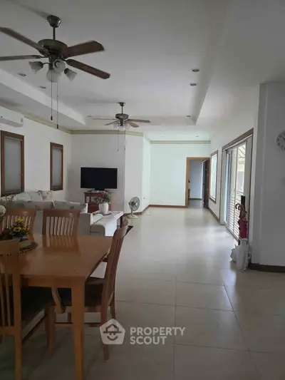 Spacious open-plan living and dining area with ceiling fans and natural light.