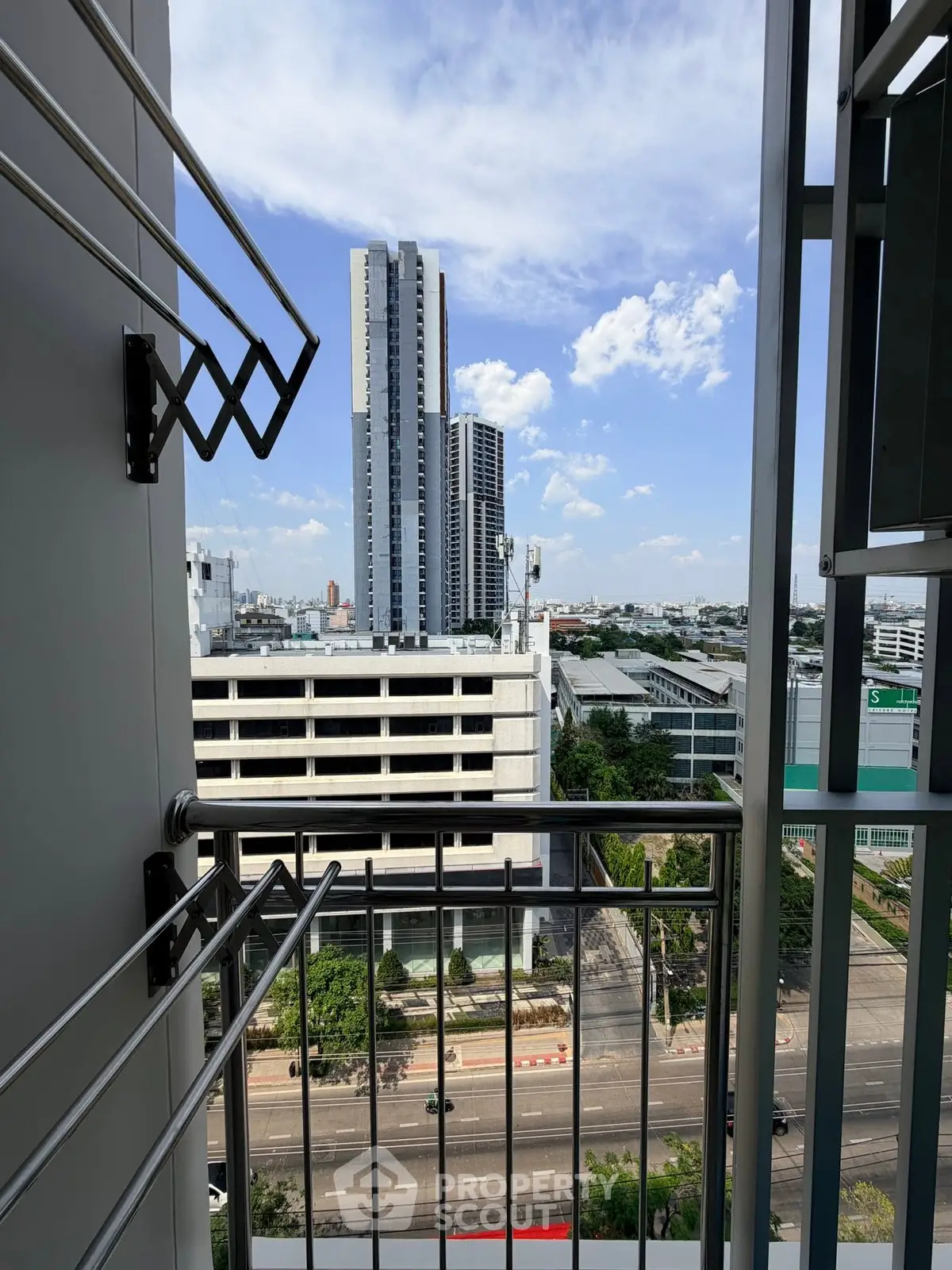Stunning city view from a modern apartment balcony, showcasing urban skyline and clear blue skies.