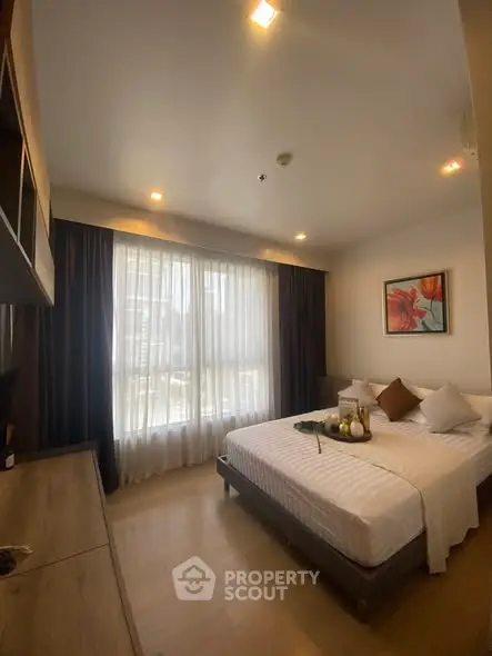 Cozy bedroom with modern decor and large window for natural light
