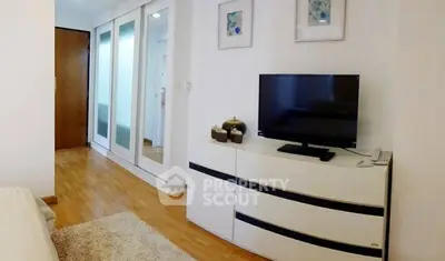 Modern bedroom with sleek TV stand and mirrored wardrobe doors.