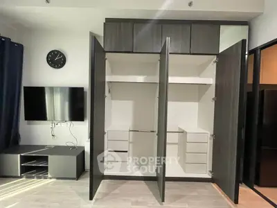Spacious modern living room with open wardrobe and wall-mounted TV