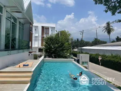 Modern residential pool with sleek design and lush surroundings, perfect for relaxation and leisure.