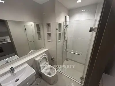 Modern bathroom with glass shower enclosure and sleek fixtures.